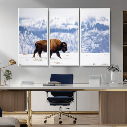 A lone bison walks across snowy ground with blue-toned mountain range behind, ideal for rustic or western farmhouse interiors.