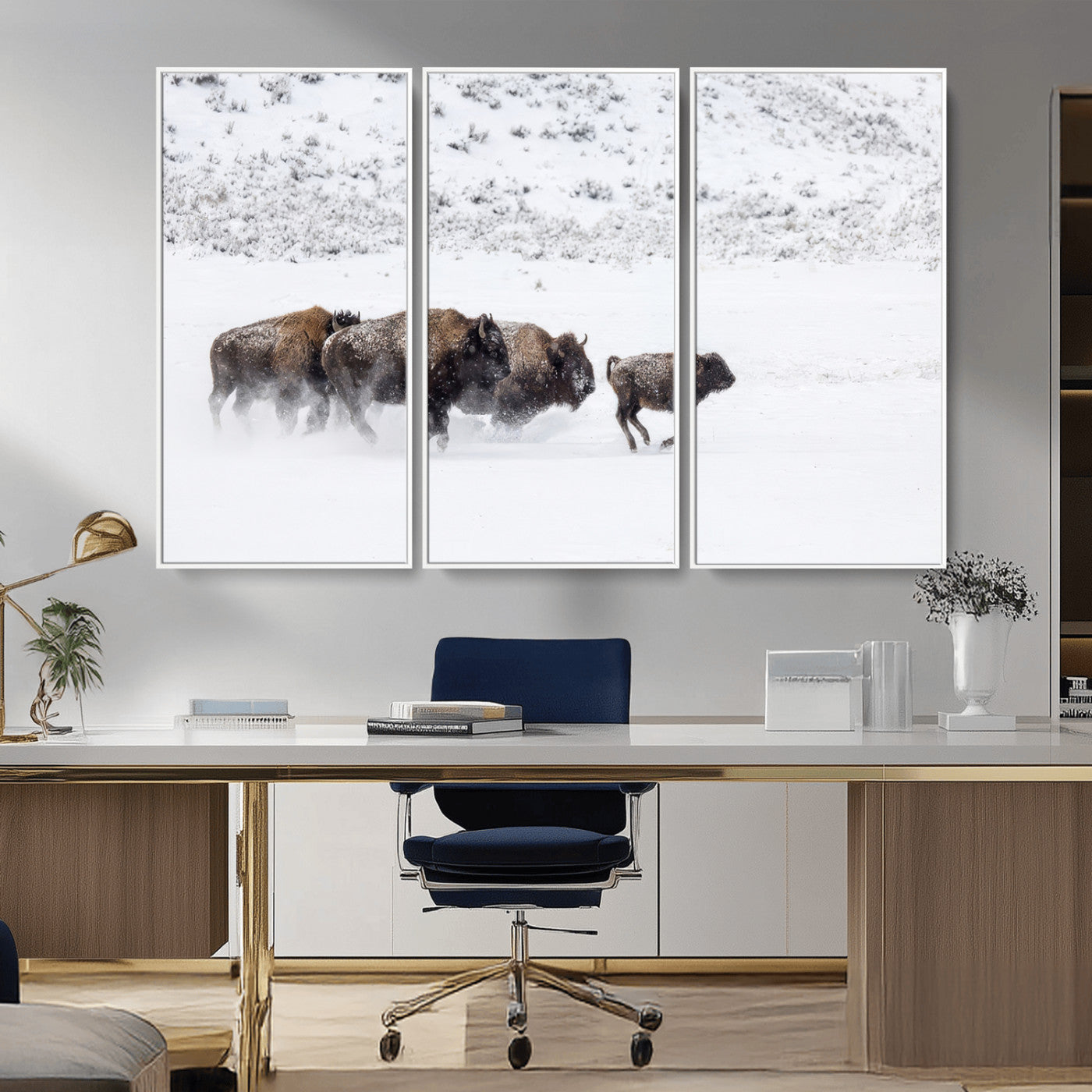 Bison herd running through a snowy open field with mountain backdrop, perfect for rustic or western-themed wall decoration.