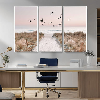 A peaceful coastal pathway leading to the ocean, with birds flying across a soft pastel sky, creating a calm and scenic beach atmosphere.