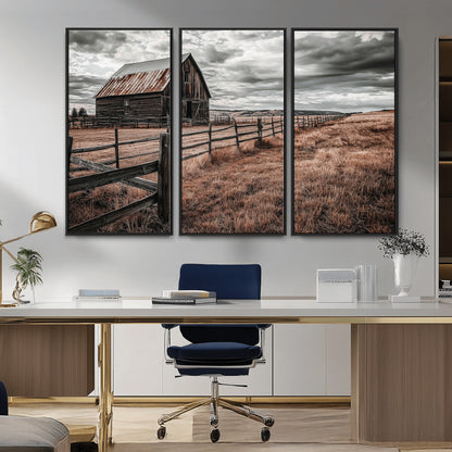 Framed canvas of a rustic barn under a moody sky with weathered fence and dark fields, ideal for farmhouse or rural-style wall decor.