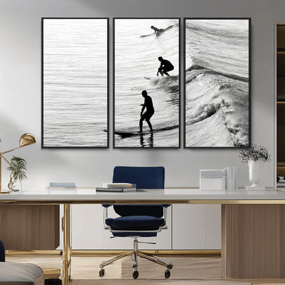 Black and white photo of surfers riding waves in a moody, high-contrast scene, ideal for modern coastal or surf-inspired home decor.