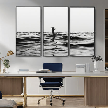 Black and white ocean with a hand making a surfer sign among dark waves, creating a dramatic and minimalist seascape with bold contrast.