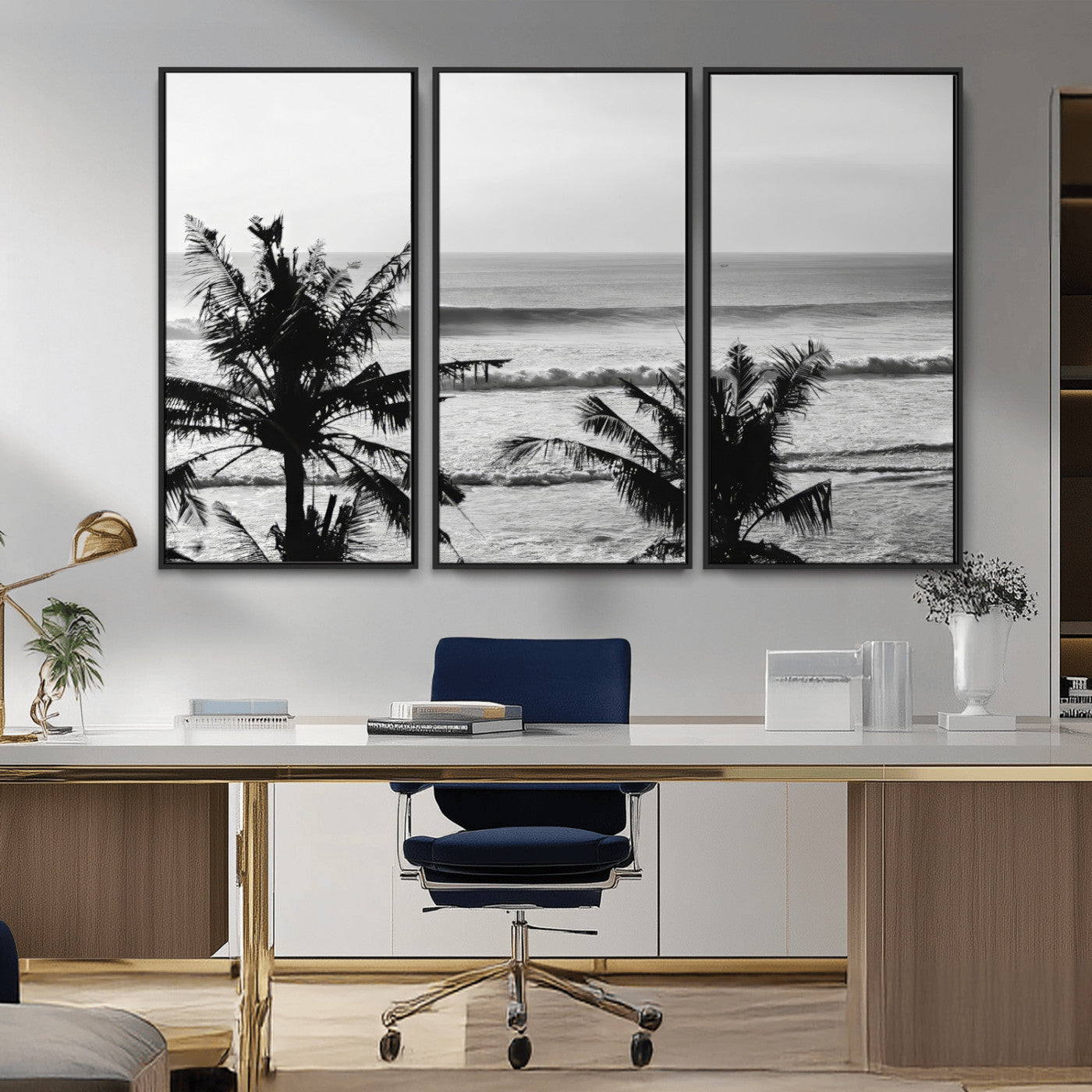 Black and white view of ocean waves crashing on a tropical coastline, framed by silhouetted palm trees under a vast, open sky.
