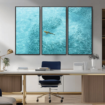 Aerial view of a shark swimming through a swirl of fish in clear turquoise waters, perfect for calm coastal or beach house decor.