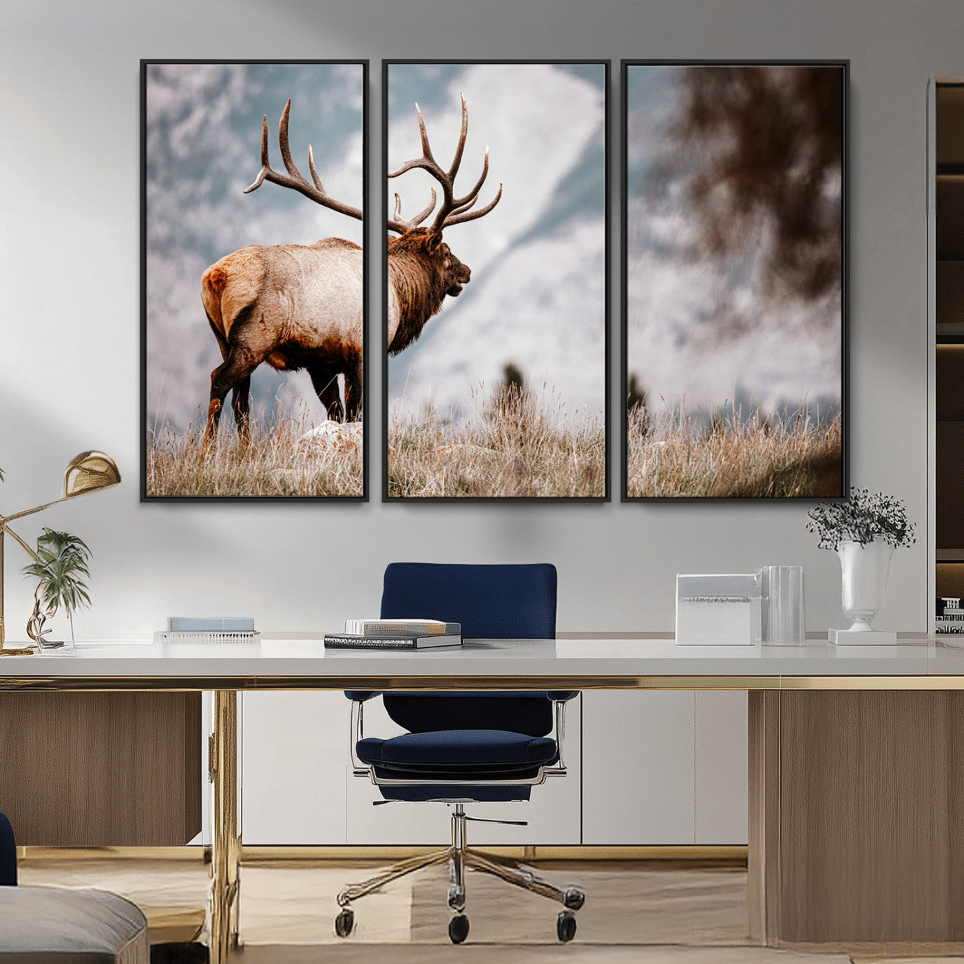 Majestic elk with large antlers standing in grass with snowy mountains in background, perfect for rustic cabin or lodge style decor.