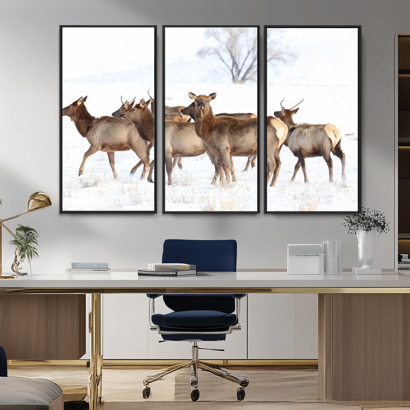 A group of elk standing on snowy terrain with a tree in the background, perfect for rustic or lodge-style winter wall decor.