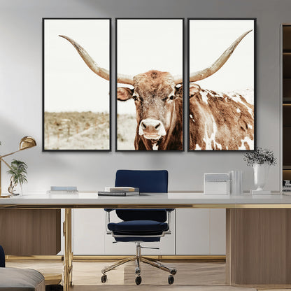A Texas longhorn bull with wide horns, standing in a dry field under soft light, ideal for rustic farmhouse or western-themed interiors.
