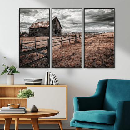 Framed canvas of a rustic barn under a moody sky with weathered fence and dark fields, ideal for farmhouse or rural-style wall decor.