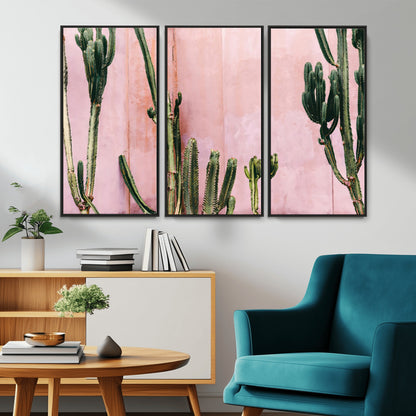 Framed canvas of tall green cacti against a soft pink wall, ideal for modern desert or colorful southwest-inspired home decor.