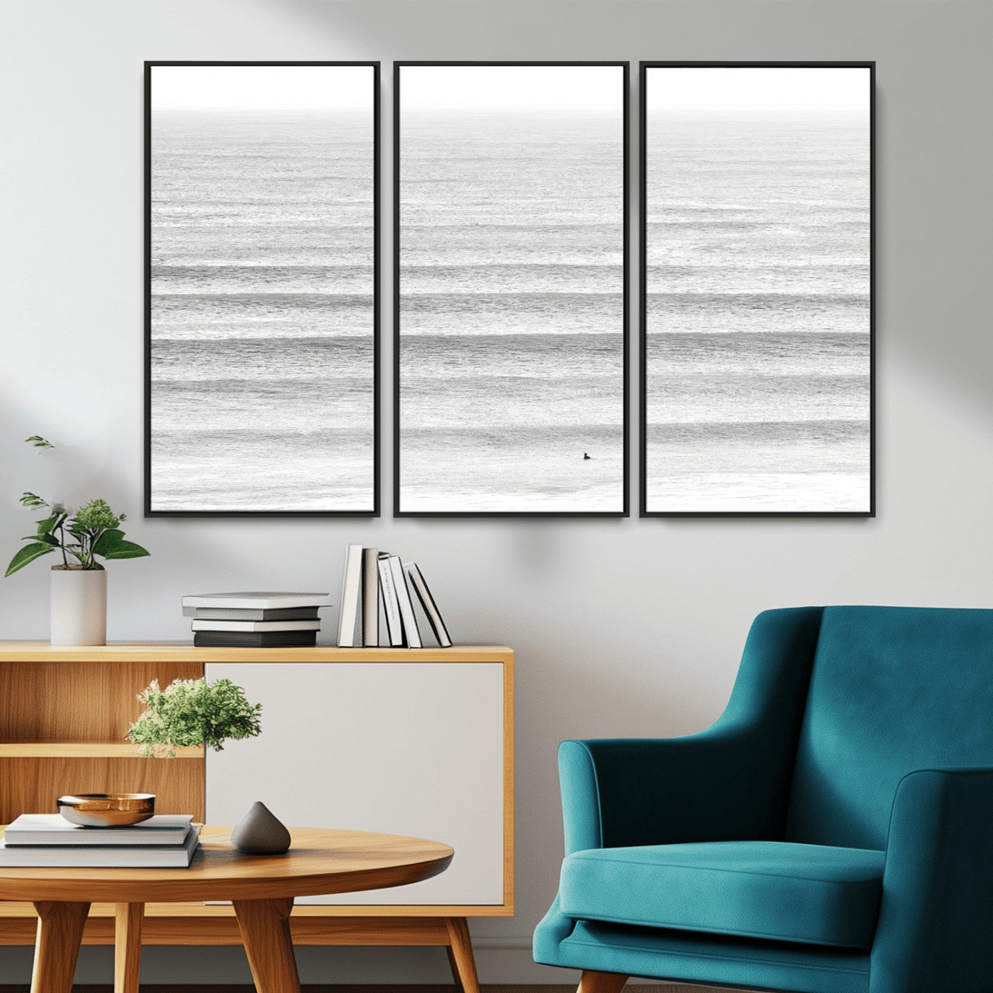 Monochrome photo of a lone surfer in calm layered waves, perfect for minimalist coastal or moody ocean-inspired wall decoration.