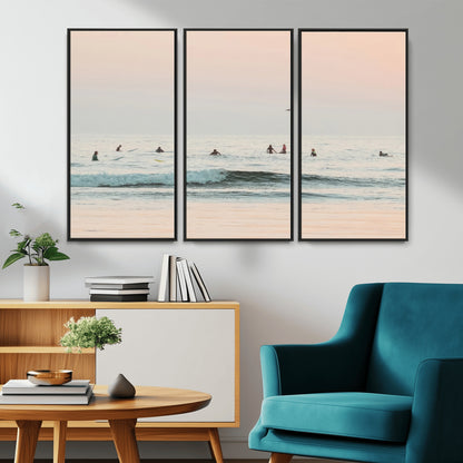 Dreamy photo of surfers waiting on soft pastel waves under a pink sunset sky, ideal for soft coastal minimalist or serene ocean-themed home decor.