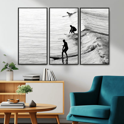 Black and white photo of surfers riding waves in a moody, high-contrast scene, ideal for modern coastal or surf-inspired home decor.