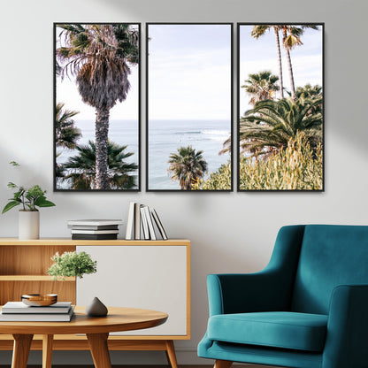 Scenic coastal view with tall palm trees overlooking a calm ocean, soft blue waves, and surfers in the distance, creating a peaceful tropical vibe.