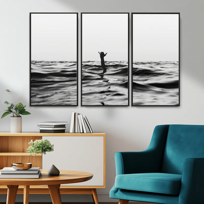 Black and white ocean with a hand making a surfer sign among dark waves, creating a dramatic and minimalist seascape with bold contrast.