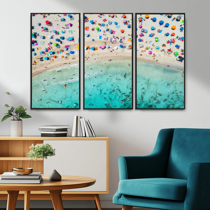 Aerial view of a vibrant beach filled with colorful umbrellas and people enjoying the turquoise ocean, capturing a lively summer vacation scene.