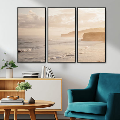 Golden hour seascape with misty cliffs and gentle waves rolling towards the shore, capturing a tranquil and warm coastal atmosphere.