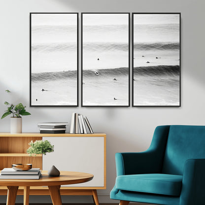 A monochrome photograph of swimmers gliding through gentle ocean waves, evoking a sense of calm and movement.