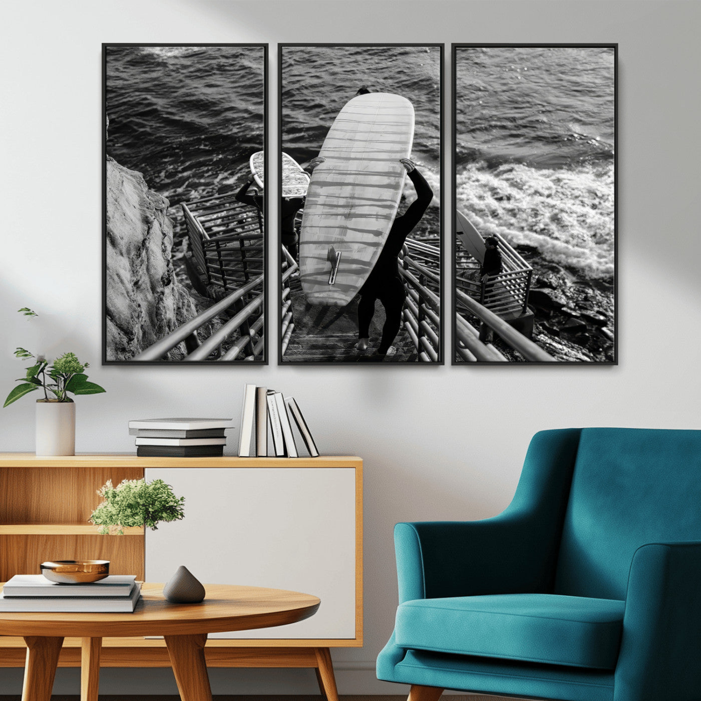 Black and white photo of surfers carrying boards down a rugged cliffside stairway, capturing a bold and adventurous coastal scene.