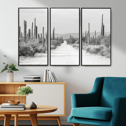 A black and white desert road stretching through a cactus-filled landscape, creating a rugged and timeless southwestern aesthetic with a sense of adventure.