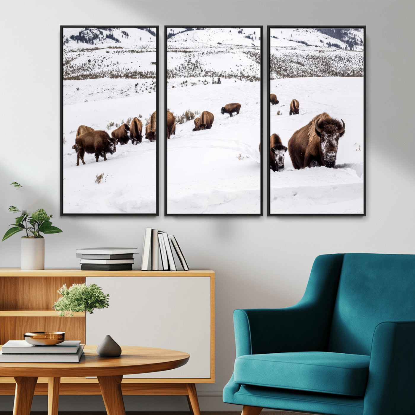 A herd of bison walking through deep snow in a mountain valley, perfect for rustic, cabin or western-themed wall decor.
