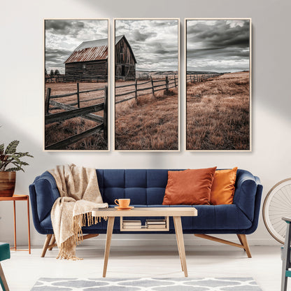 Framed canvas of a rustic barn under a moody sky with weathered fence and dark fields, ideal for farmhouse or rural-style wall decor.