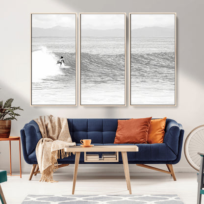 Monochrome photo of a surfer riding a wave with distant mountains, ideal for coastal motion or black and white surf-themed wall decor.