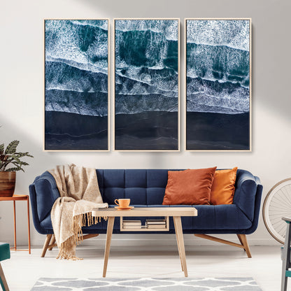 Canvas of aerial ocean waves crashing onto a black sand beach in moody tones, ideal for modern coastal or minimalist home decor.