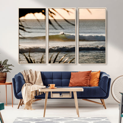 Photo of a surfer riding a golden hour wave at sunset, with tropical tones and dreamy light, perfect for tropical boho or coastal home decor.