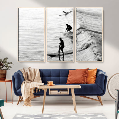 Black and white photo of surfers riding waves in a moody, high-contrast scene, ideal for modern coastal or surf-inspired home decor.