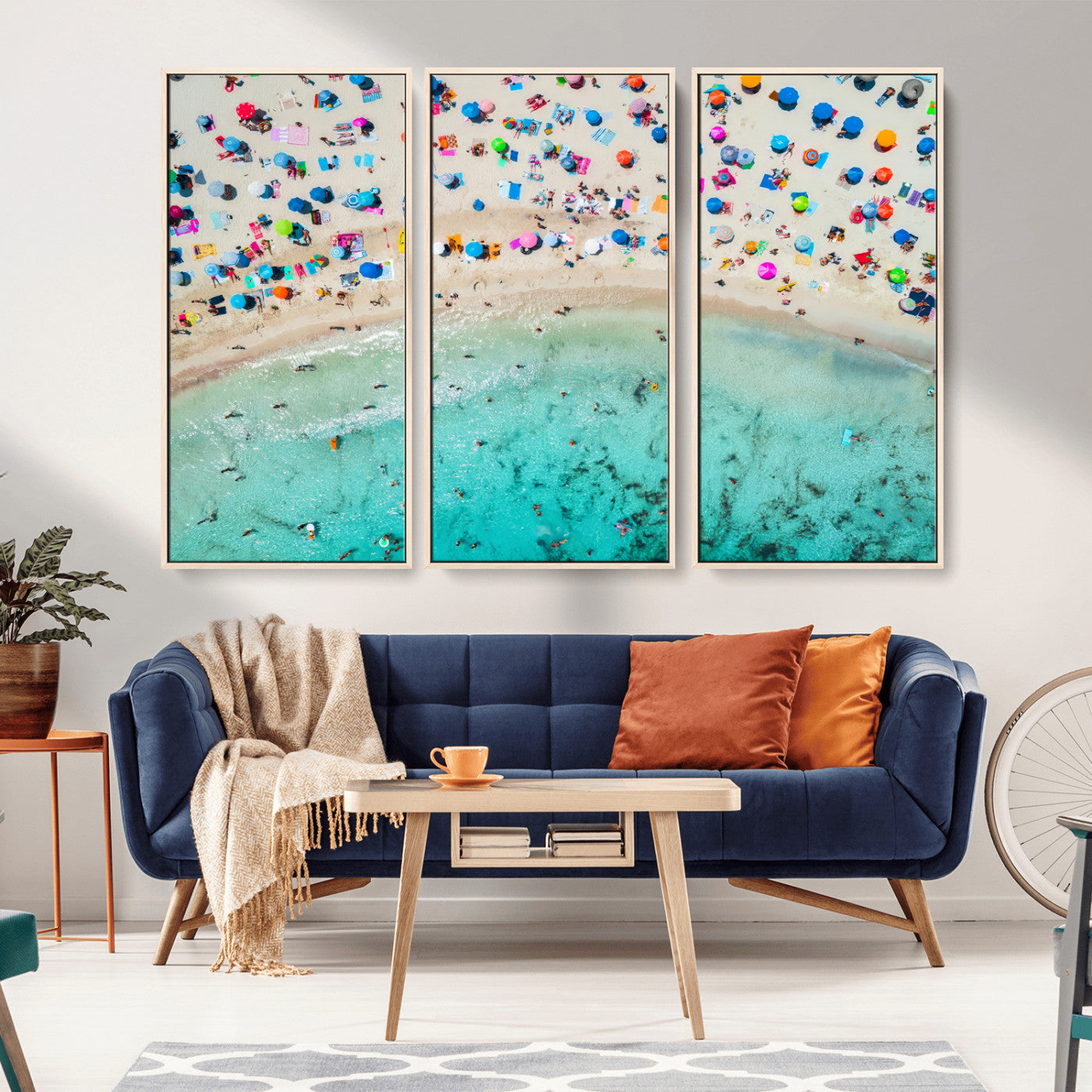 Aerial view of a vibrant beach filled with colorful umbrellas and people enjoying the turquoise ocean, capturing a lively summer vacation scene.