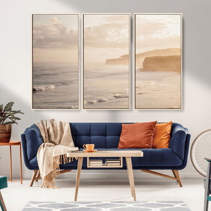 Golden hour seascape with misty cliffs and gentle waves rolling towards the shore, capturing a tranquil and warm coastal atmosphere.