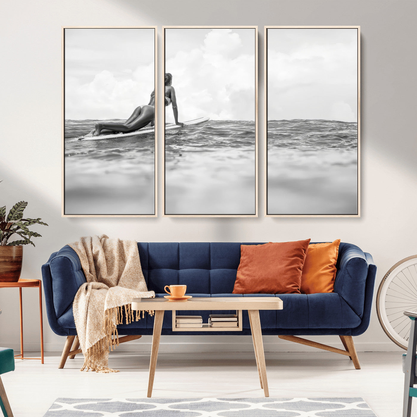 A black and white ocean scene featuring a surfer girl waiting on her board, gazing at the horizon, capturing a tranquil and adventurous coastal moment.