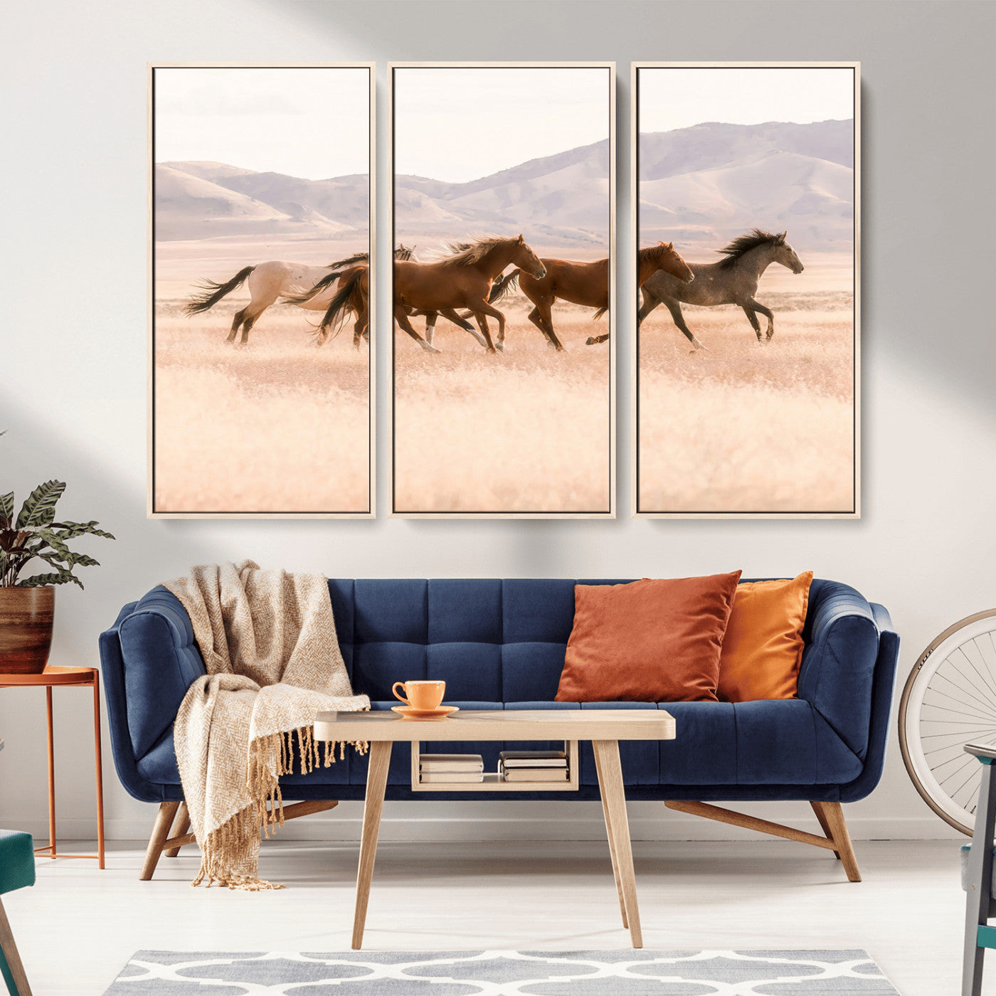 A herd of wild horses galloping through a sunlit desert plain with mountains in the background, perfect for rustic or western-themed wall decor.