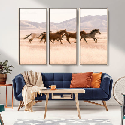 A herd of wild horses galloping through a sunlit desert plain with mountains in the background, perfect for rustic or western-themed wall decor.