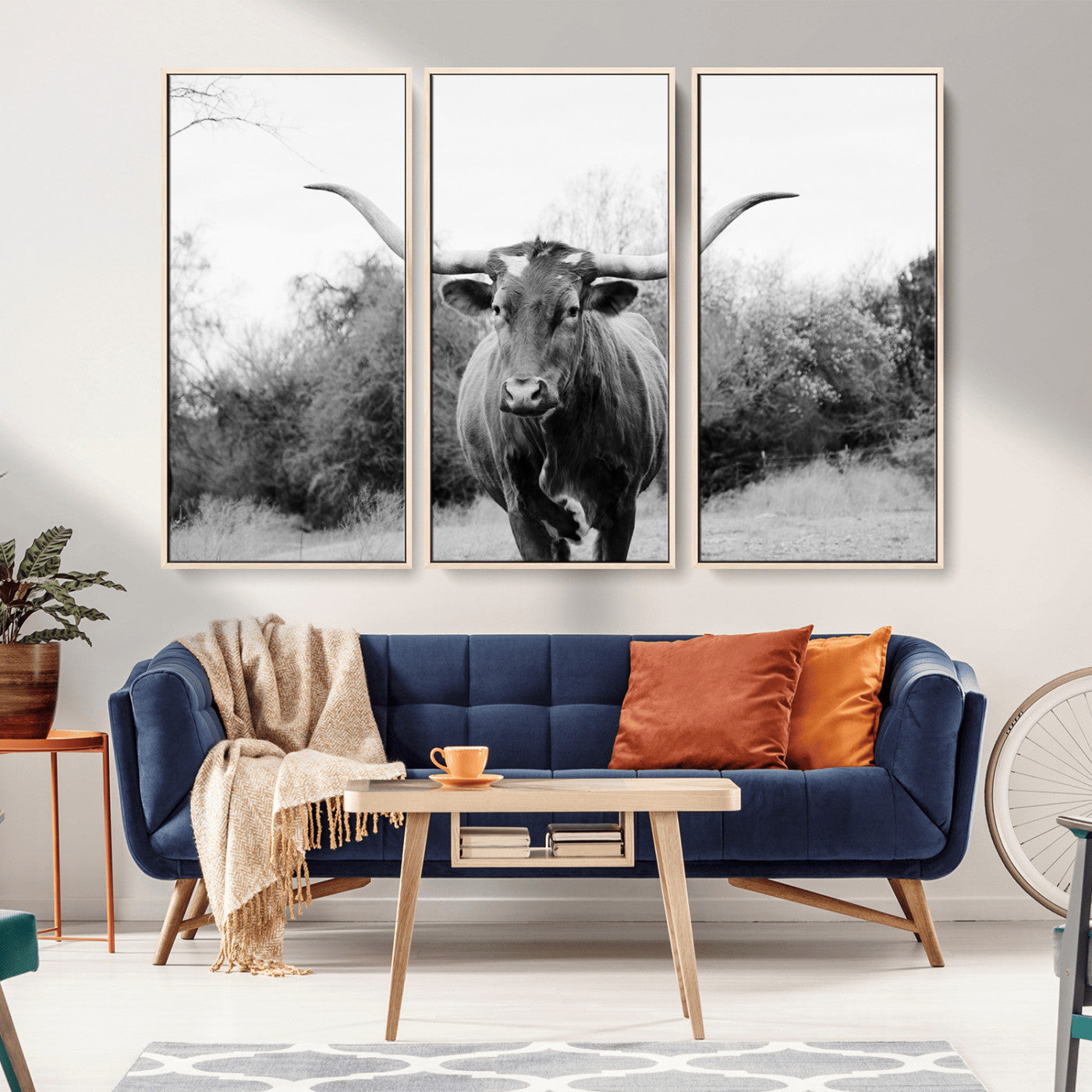 Black and white photo of a longhorn cow in a field, perfect for rustic farmhouse or western-themed interior wall decoration.