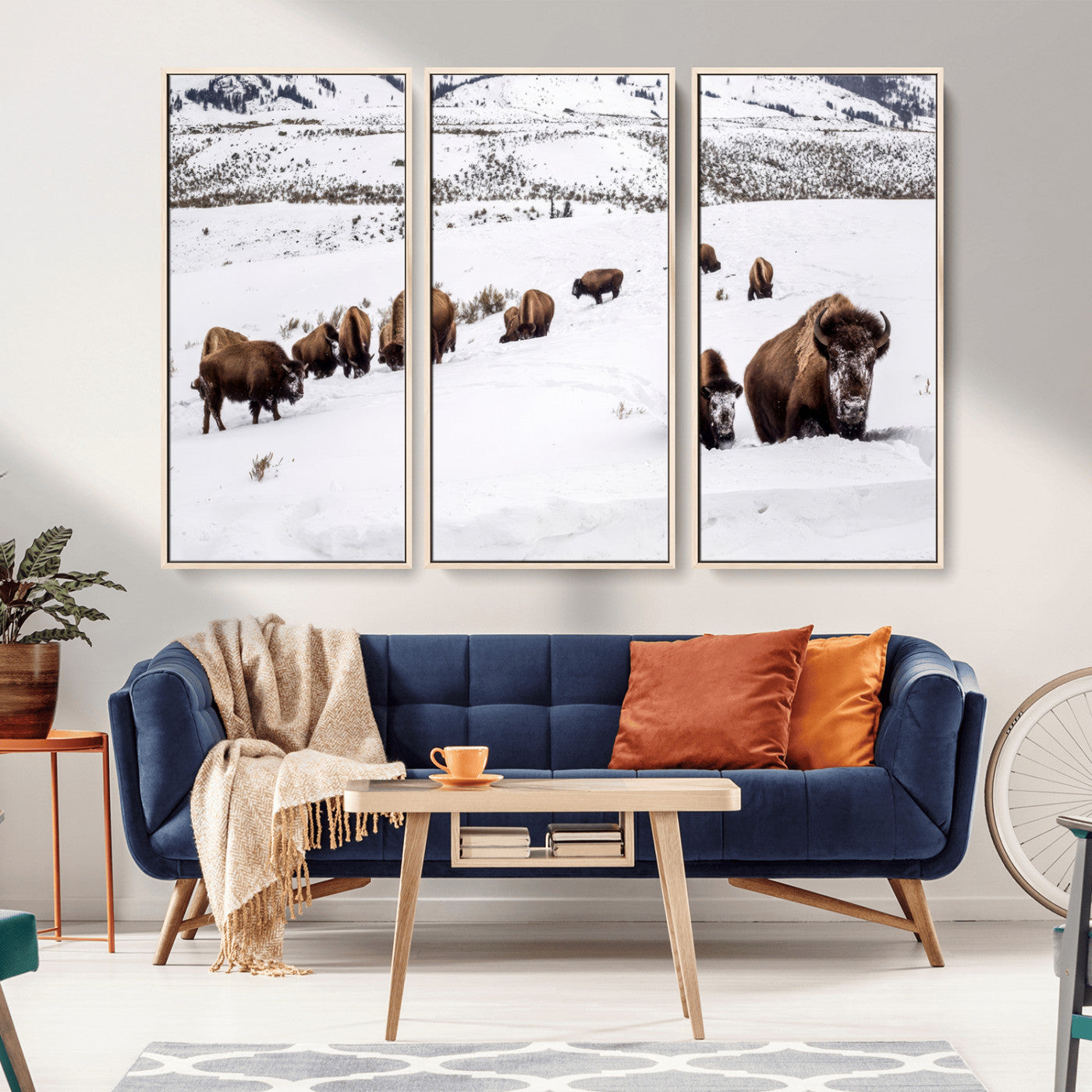 A herd of bison walking through deep snow in a mountain valley, perfect for rustic, cabin or western-themed wall decor.