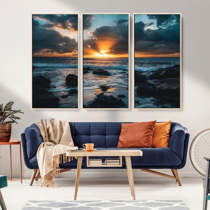 An awe-inspiring sunset over the ocean with rays of light piercing through dramatic clouds, creating a beautiful seascape with rocks in the foreground.