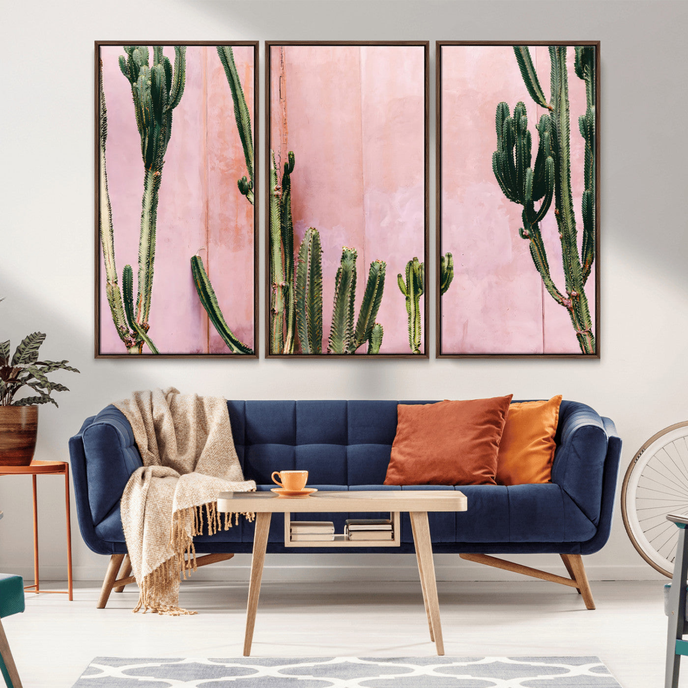 Framed canvas of tall green cacti against a soft pink wall, ideal for modern desert or colorful southwest-inspired home decor.