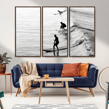 Black and white photo of surfers riding waves in a moody, high-contrast scene, ideal for modern coastal or surf-inspired home decor.