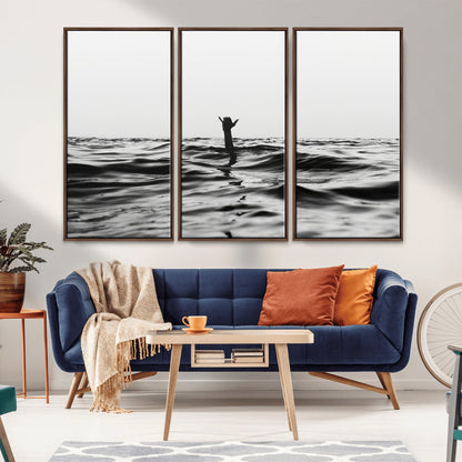 Black and white ocean with a hand making a surfer sign among dark waves, creating a dramatic and minimalist seascape with bold contrast.