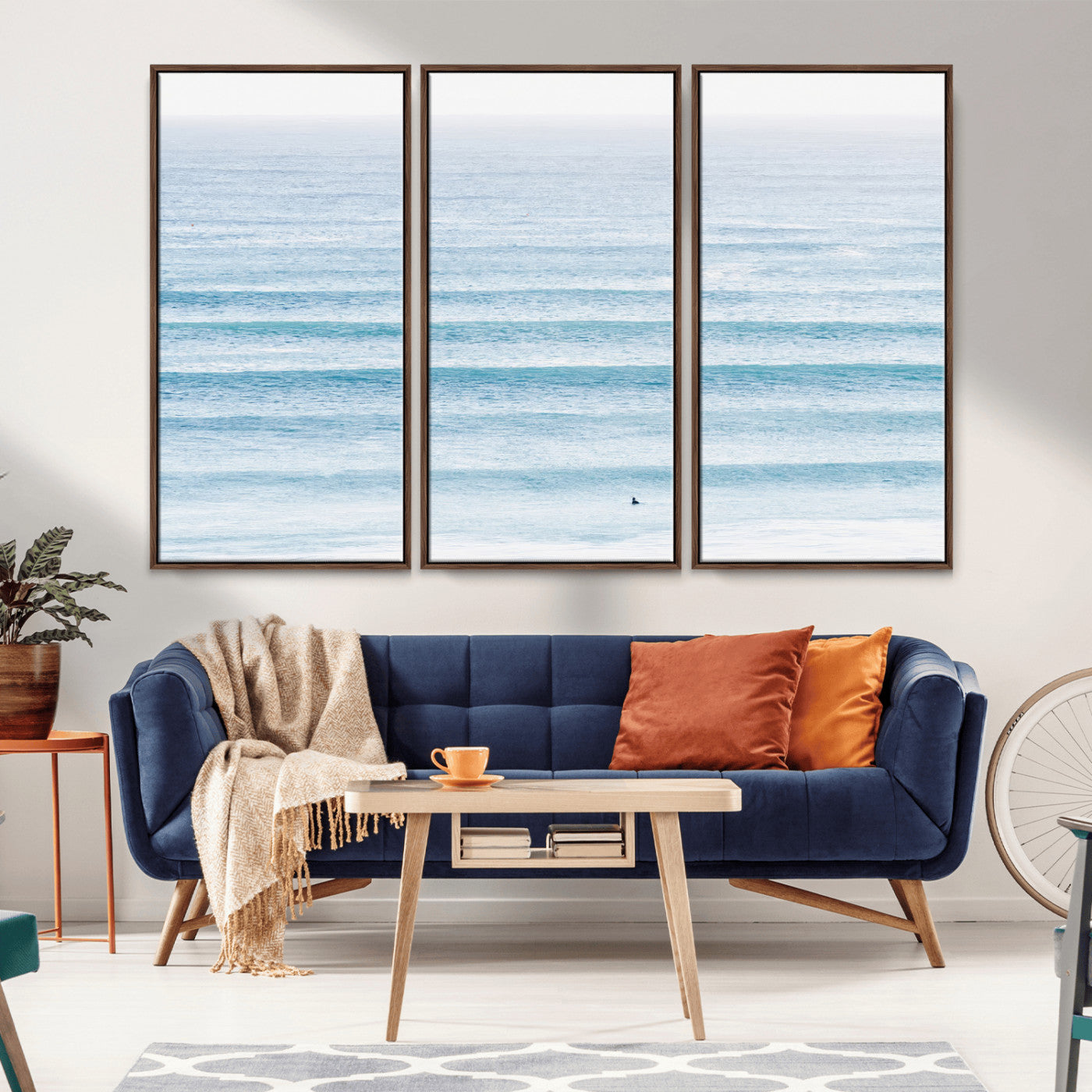 Minimalist ocean view with soft blue waves and a lone surfer, creating a serene and airy coastal aesthetic, perfect for tranquil home decor.