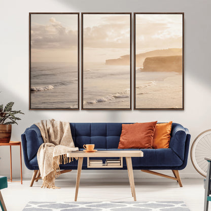 Golden hour seascape with misty cliffs and gentle waves rolling towards the shore, capturing a tranquil and warm coastal atmosphere.