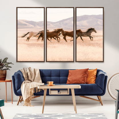 A herd of wild horses galloping through a sunlit desert plain with mountains in the background, perfect for rustic or western-themed wall decor.