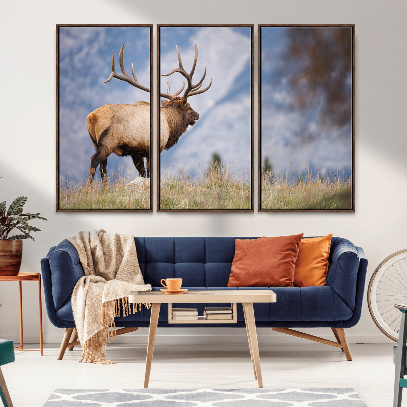 Elk with antlers standing on grass with mountain background, ideal for rustic, cabin, or lodge-inspired wall decor.