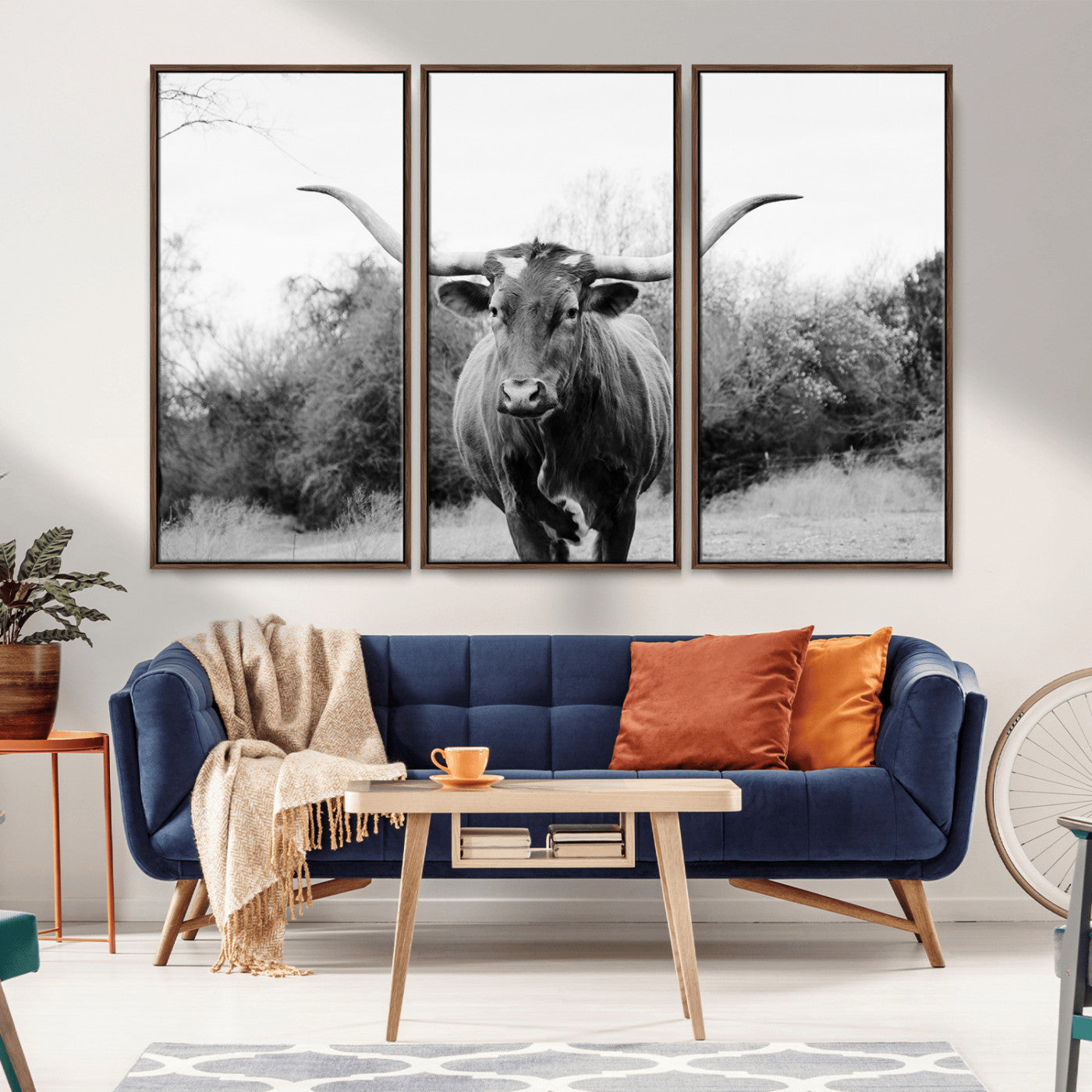 Black and white photo of a longhorn cow in a field, perfect for rustic farmhouse or western-themed interior wall decoration.
