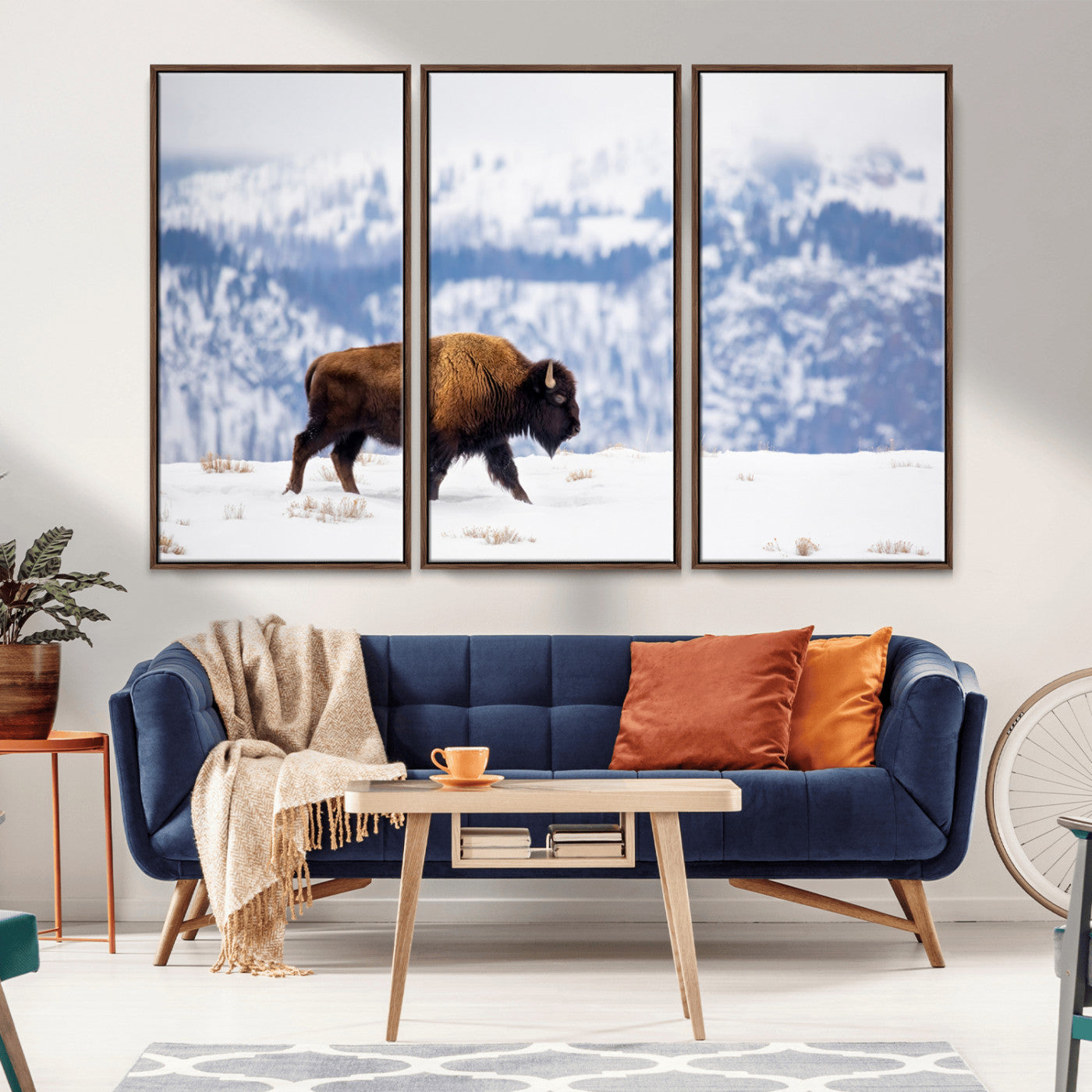 A lone bison walks across snowy ground with blue-toned mountain range behind, ideal for rustic or western farmhouse interiors.