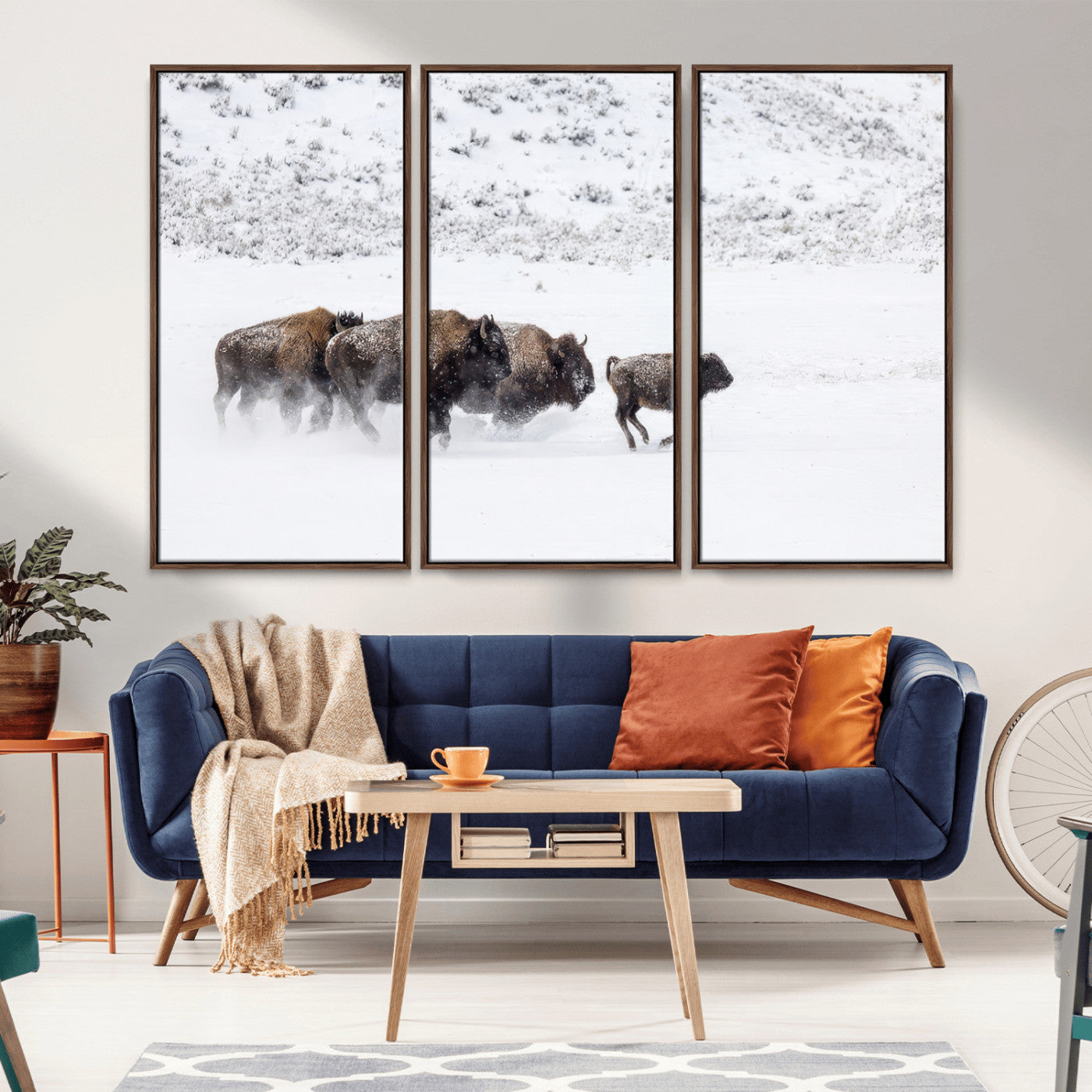Bison herd running through a snowy open field with mountain backdrop, perfect for rustic or western-themed wall decoration.