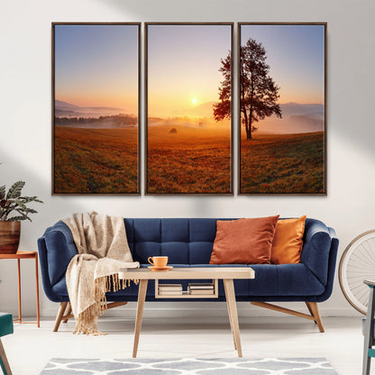 A tranquil landscape at sunrise with a mist-covered field and a lone tree, creating a peaceful and natural atmosphere.