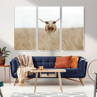 Texas Longhorn bull standing alone in dry grass with neutral tones, ideal for rustic western or cowboy-themed wall decor.