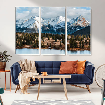 Framed canvas of snowy mountain peaks with pine forest and alpine lake, perfect for winter cabin or wilderness-inspired home decor.